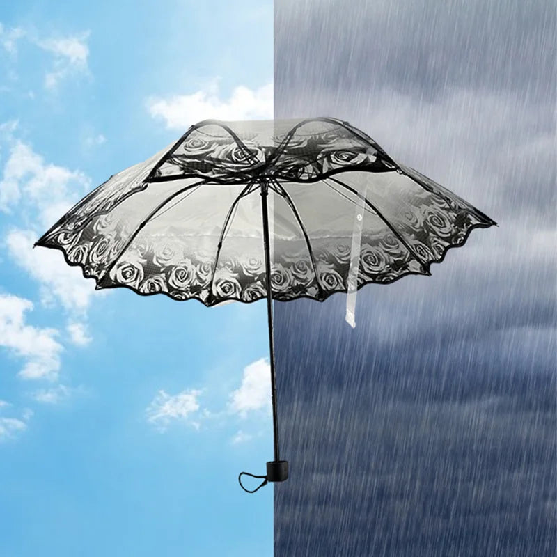 A black umbrella with a transparent canopy featuring floral designs is held against a modern glass building.