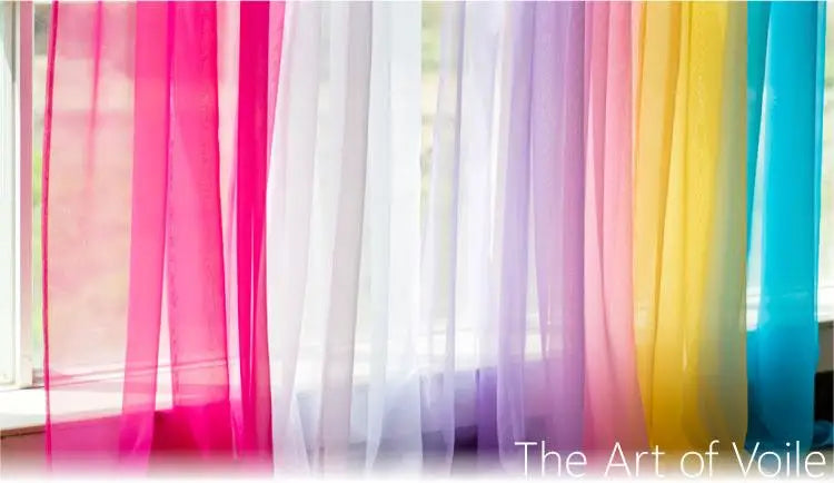 A collection of sheer voile curtains in various pastel colors, including pink, white, lavender, and yellow, hanging by a wind