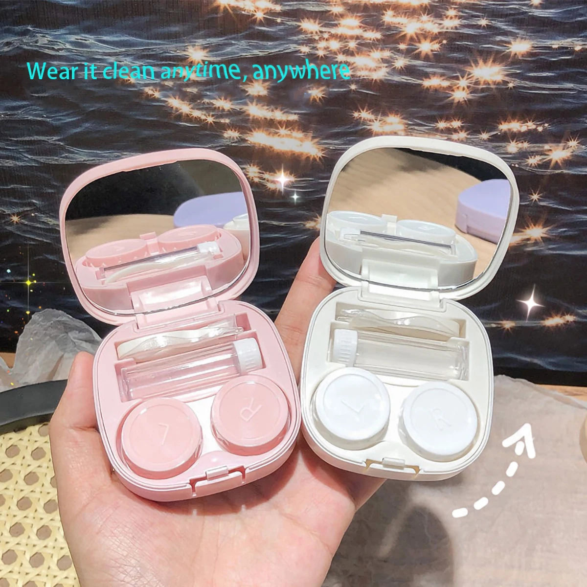 A hand holds an open pink and white compact contact lens travel case with secure closures.