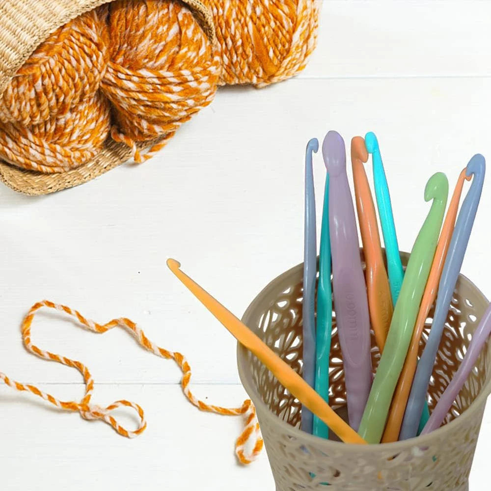 A collection of colorful plastic crochet hooks in various sizes stored in a woven basket.