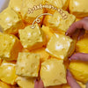 A close-up shot of yellow, squishy fidget cubes being held by a hand.