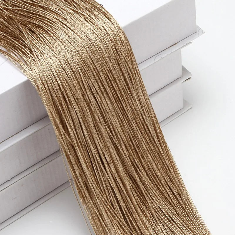 Golden metallic beaded thread curtain hanging, showing the texture and length of the fabric.