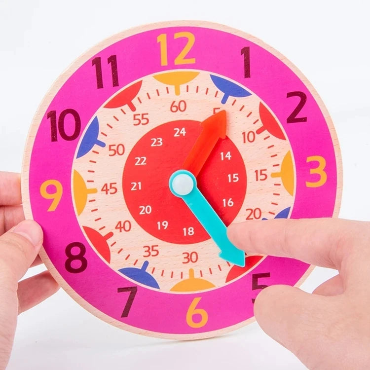 A hand is pointing at a pink wooden clock face with colorful markings and an orange hand.
