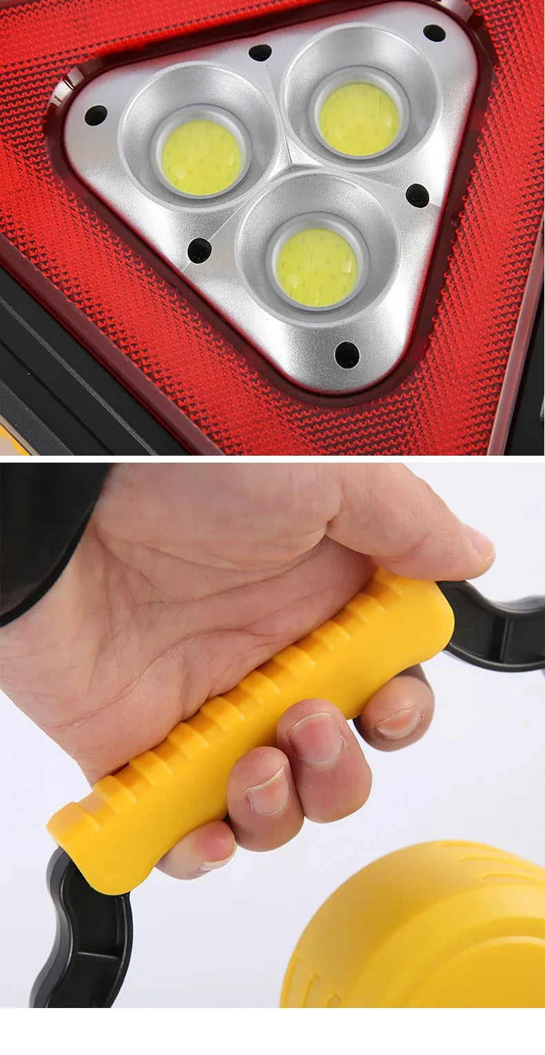 Close-up of a red emergency triangle warning light with three yellow reflectors and a yellow handle.