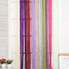 Vertical curtain made of multicolored beaded threads hanging in a window frame.