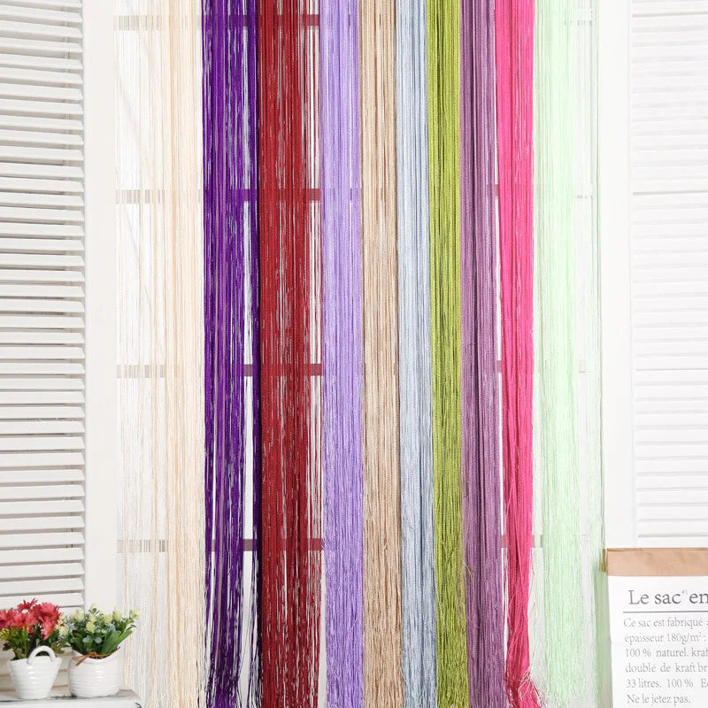 Vertical curtain made of multicolored beaded threads hanging in a window frame.