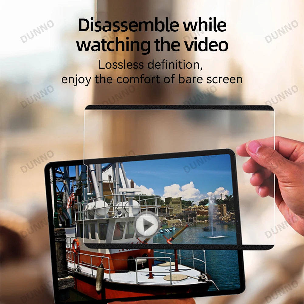 A hand holds a tablet with a clear screen protector installed, showing a view of a boat.