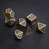 A collection of bronze metal polyhedral dice including a d6, d8, d10, d12, and d20 resting on a dark surface.