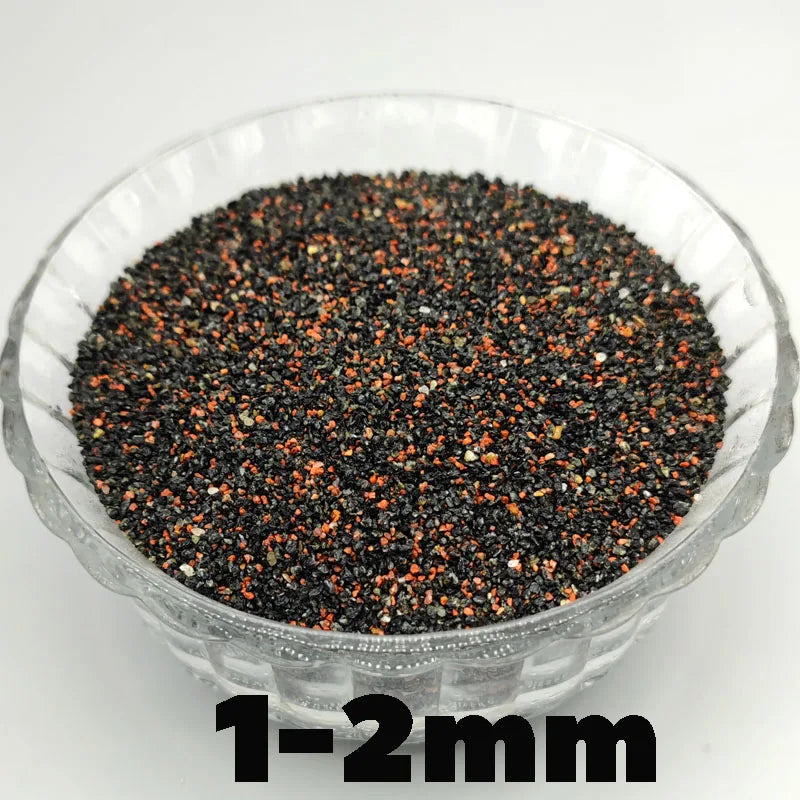 A clear bowl filled with black and orange decorative stone pebbles measuring 1-2mm.
