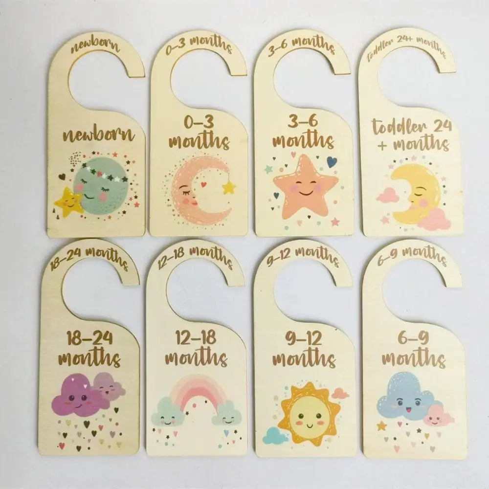 A set of wooden baby closet dividers with cartoon labels for newborn, 0-3 months, 3-6 months, and toddler ages.