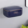 A dark blue, rectangular two-tier draining soap holder mounted on a gray wall.