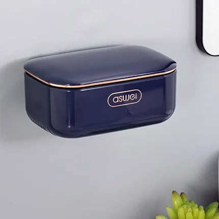A dark blue, rectangular two-tier draining soap holder mounted on a gray wall.
