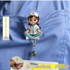 A 2D pendant of a nurse-themed doll with a medical uniform and ID clip against a blue fabric background.