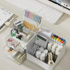 A white desk organizer with transparent drawers holds various stationery items like pens, pencils, and rulers.