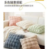 A collection of various colored plush decorative pillow covers displayed on a white sofa.