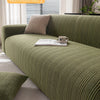A moss green quilted sofa set featuring a textured fabric and neutral pillows in a bright living room setting.