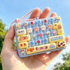 A hand holds a clear silicone case filled with colorful cartoon keycaps and fidget elements.
