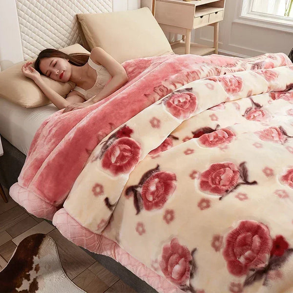 A pink and cream weighted plush blanket with a floral pattern is displayed on a bed.