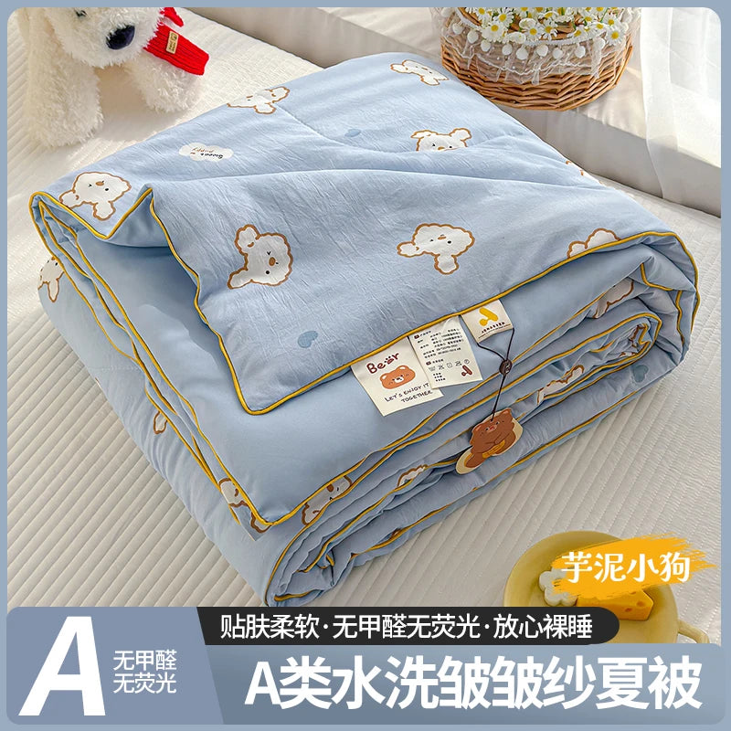A lightweight summer quilt with a playful cartoon print featuring small bear motifs in light blue.