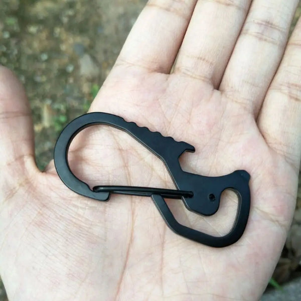 Schwarzer Edelstahl-Multitool-Karabiner als Schlüsselanhänger in der Hand einer Person.