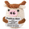 A handcrafted crocheted plush ornament shaped like a cow with brown horns and pink face.