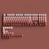 A close-up view of a PBT double-shot keycap set with gradient colors arranged on a flat surface.