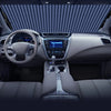 Interior view of a car showing the steering wheel, dashboard, and center console with a sunshade visible on the windshield.