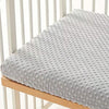 Housse de matelas en peluche texturée gris clair pour berceau ou lit.