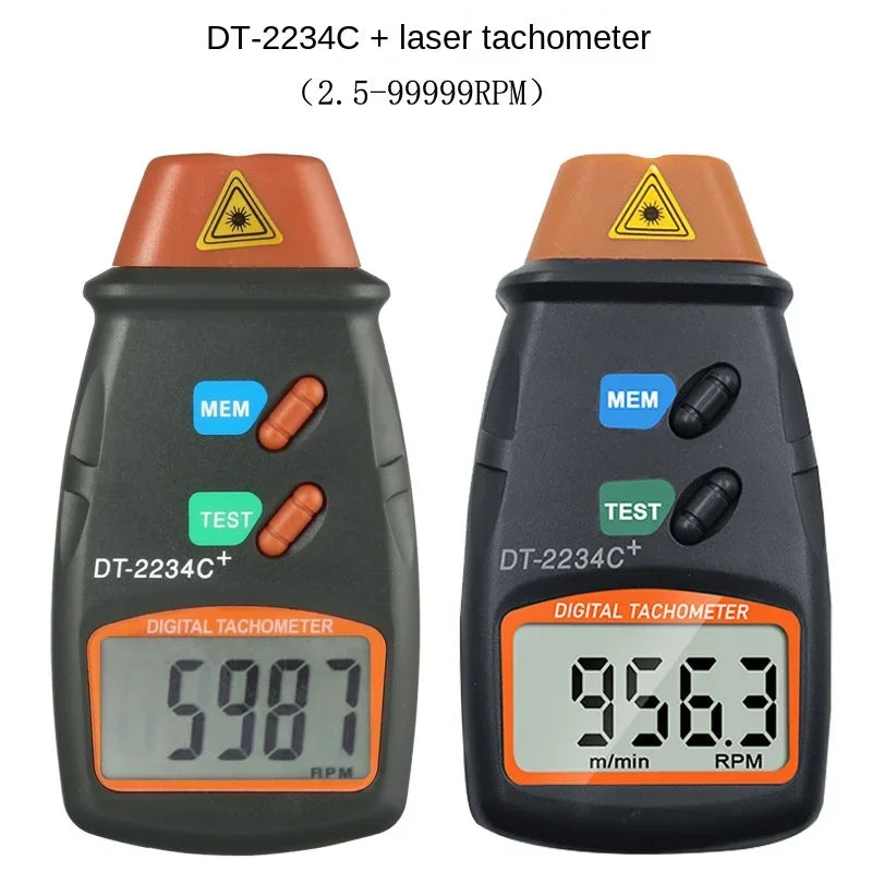 A black digital laser tachometer device with a yellow warning triangle and an orange display showing 956.3 RPM.