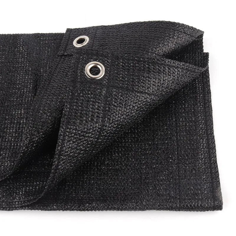 Black HDPE privacy screen fabric folded and showing grommets for balcony or patio use