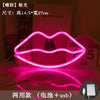 A pink LED lip neon sign shaped like lips, illuminated on a surface.