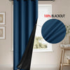 A dark blue blackout curtain hanging in a window frame, showing its full drape and black lining.