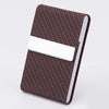 A brown patterned slim card holder with a white leather insert and stainless steel closure.