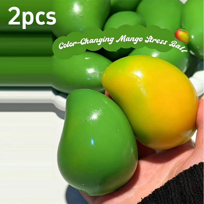 Zwei farbwechselnde Mango-Stressbälle, einer grün und einer gelb, in einer Hand.
