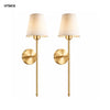 A pair of gold-toned rechargeable LED wall sconces with cream fabric shades.