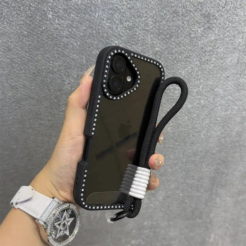 Una mano sostiene una funda negra con correa de muñeca y un teléfono transparente contra un fondo gris.