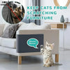 A cat is sitting on a protective mat placed on a sofa, preventing scratches on the furniture.