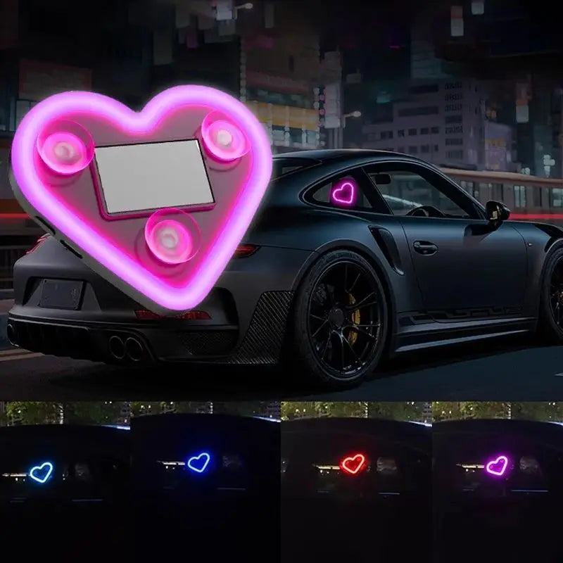 A dark sports car is illuminated by a large, glowing pink heart shape projected onto its hood and surrounding area.