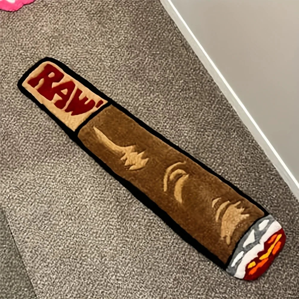 A rectangular brown accent mat with red lettering and carved designs lies on a gray carpet.