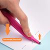 A hand is pressing down on a pink magnetic staple remover pen to remove staples from paper.