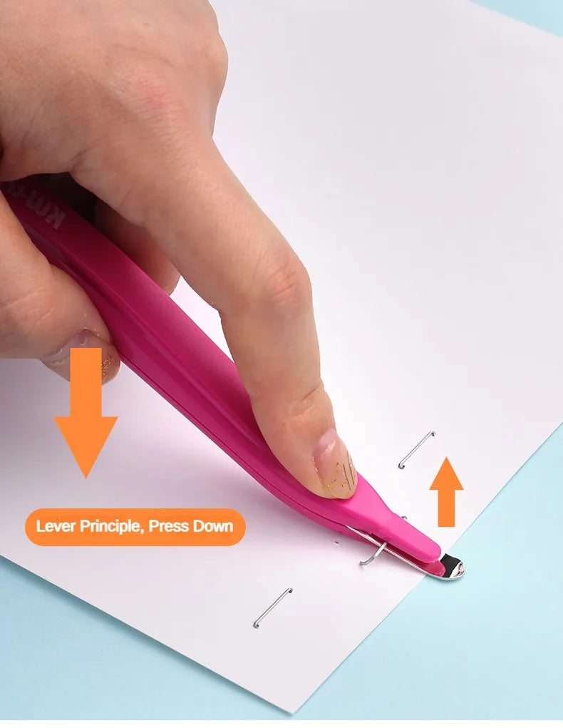A hand is pressing down on a pink magnetic staple remover pen to remove staples from paper.