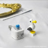 A white seagull-shaped fidget toy keychain with an LED light resting on a white surface.