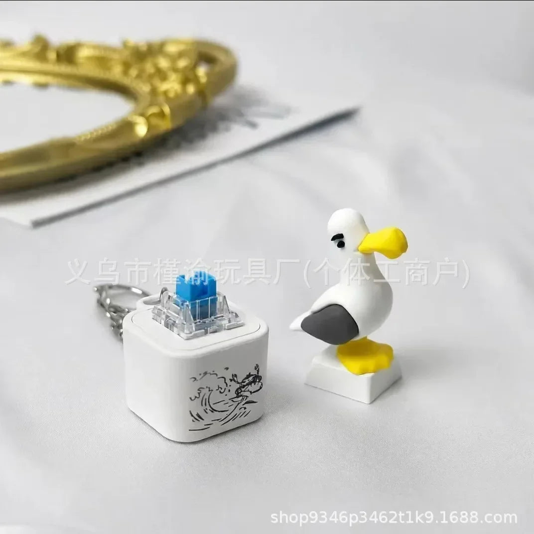 A white seagull-shaped fidget toy keychain with an LED light resting on a white surface.