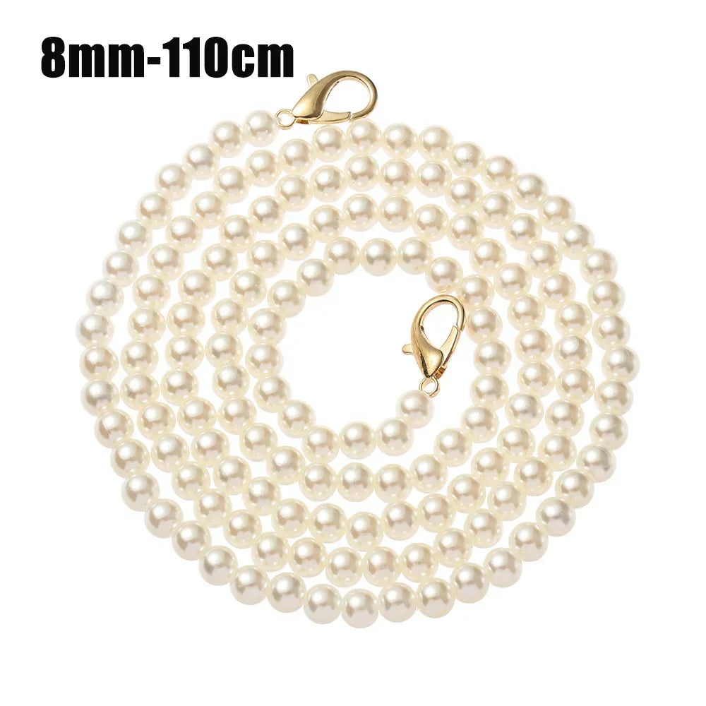 A strand of small, round, cream-colored pearls on a gold-toned chain for bags or purses.