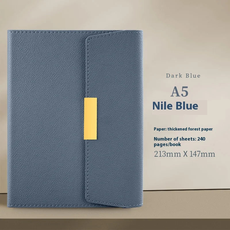 A dark blue A5 journal notebook with a gold spine and a light brown background.