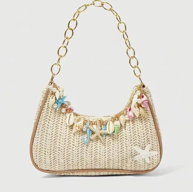 A beige woven straw shoulder bag decorated with colorful ocean shell charms.