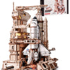 A detailed wooden model kit of a space shuttle with an accompanying launch simulator and display stand.