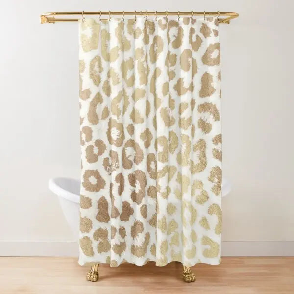A beige and gold leopard print shower curtain hanging from a brass rod.