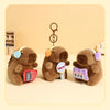 Three brown capybara plush keychains with musical instrument accessories sitting on a light background.