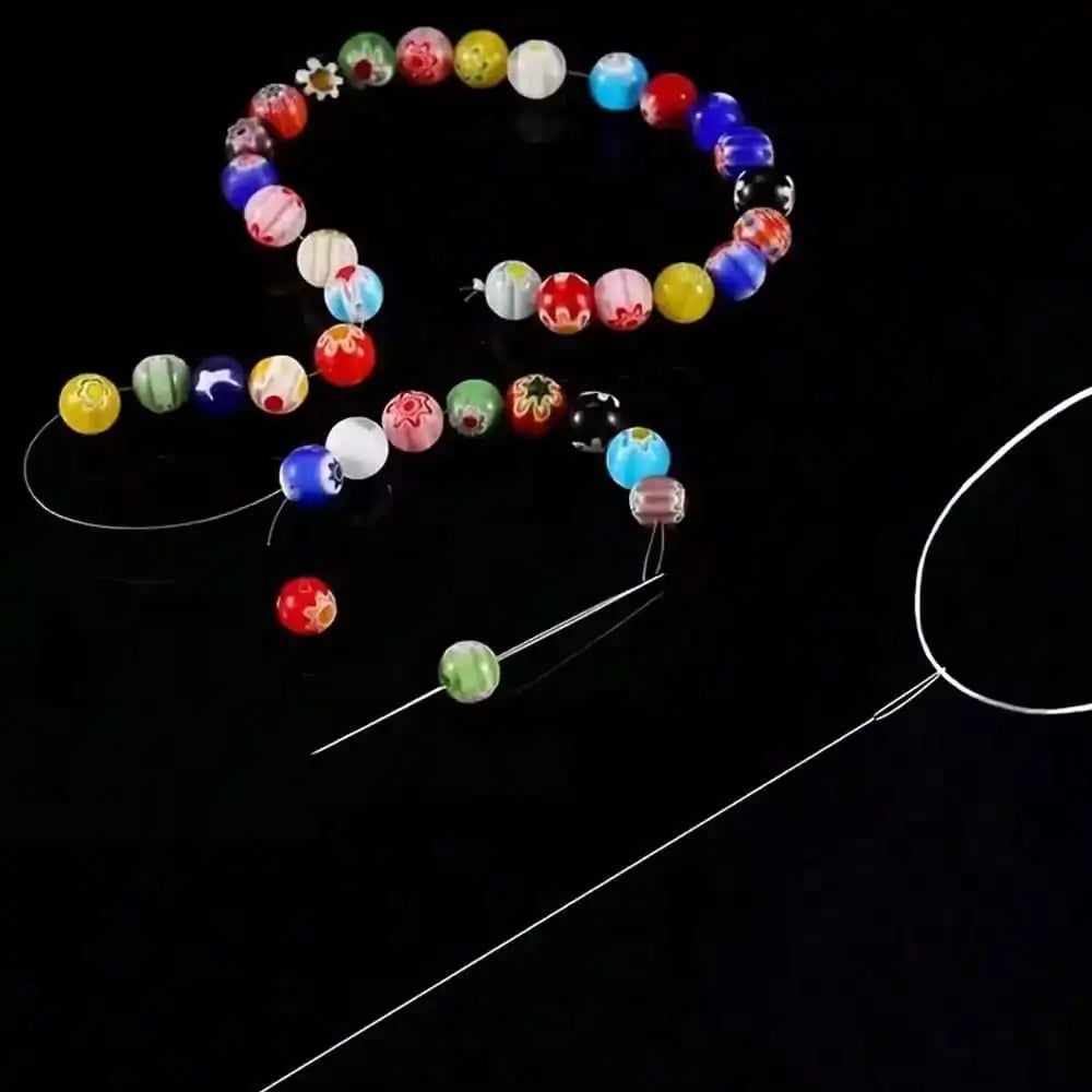 A set of seven colorful beads and a needle for jewelry making